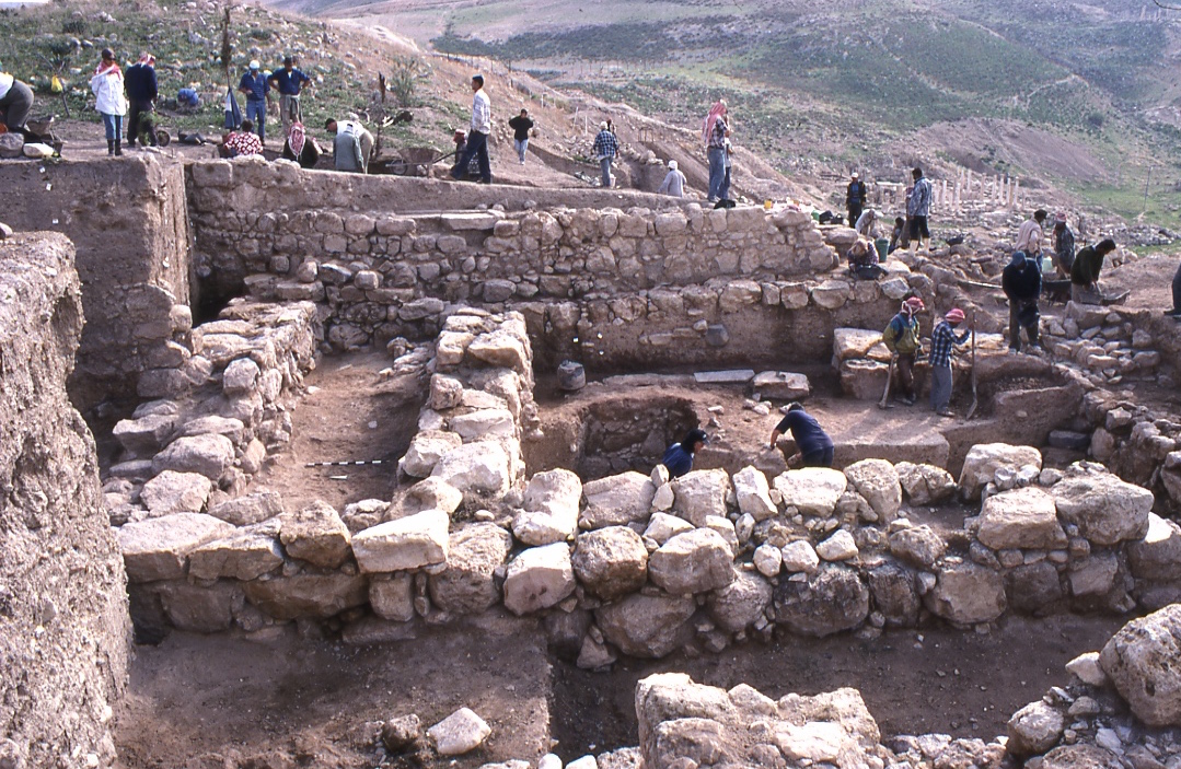 Archaeologists excavating stone walls and ancient structures at the Iron Age temple complex in Pella, Jordan.