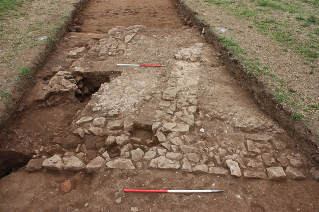 Stone wall foundations and preserved Roman opus signinum flooring uncovered in Trench 1 at the Rossett Roman villa, North Wales.