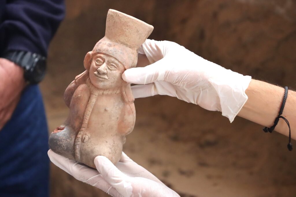 Ancient Moche ceramic figure depicting a bound prisoner with a rope around his neck, discovered in a tomb in Peru.